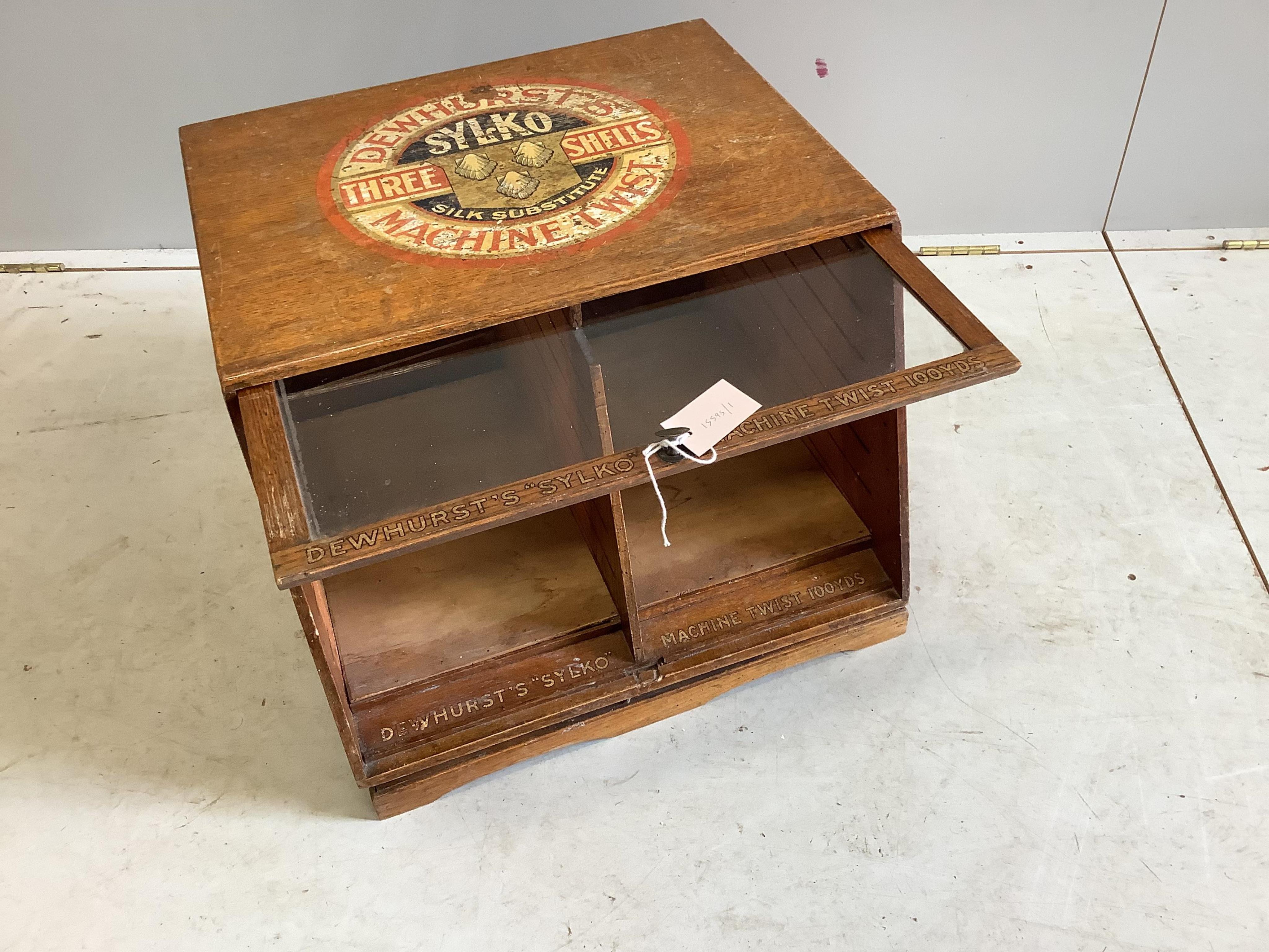 An early 20th century oak counter top display case, “Dewhurst’s Sylko Three Shells Machine Twist”, on swivel base, width 54cm, depth 52cm, height 42cm. Condition - fair